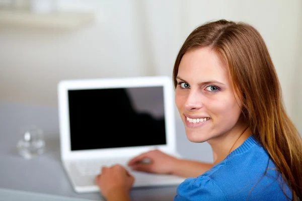 Gülümseyen ve dizüstü bilgisayarınızda çalışan sarışın kadın — Stok fotoğraf