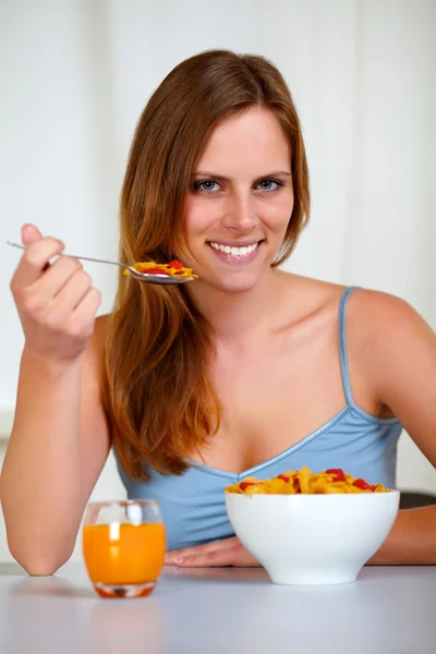 Relaxed pretty young woman eating breakfast — Stock Photo, Image