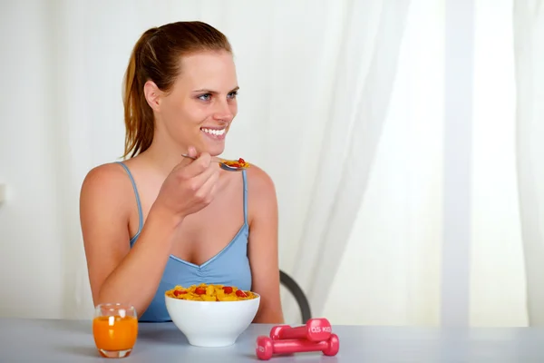 Vackra vackra kvinnan ler och äta hemma — Stockfoto