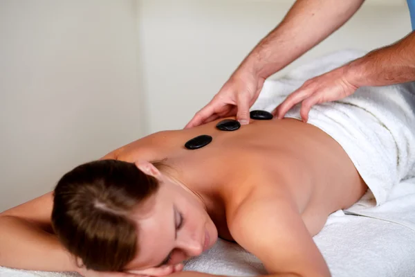 Mooie vrouw krijgt een massage met hete stenen — Stockfoto