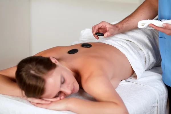 Kvinna avkopplande samtidigt ha en massage med varma stenar — Stockfoto