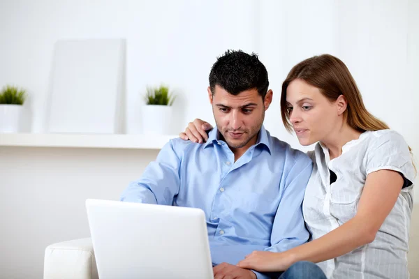 Interested couple browsing on laptop — Stock Photo, Image