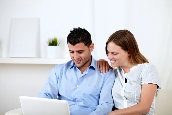 Ung kvinna med hennes pojkvän tittar på laptop — Stockfoto