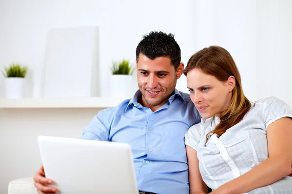 Beautiful young couple using laptop together — Stock Photo, Image