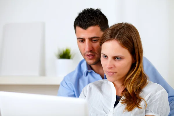 Attraktiva unga par med laptop tillsammans — Stockfoto