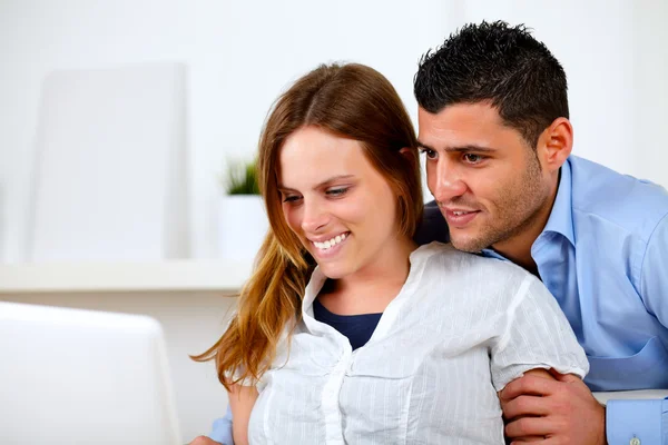 Encantadora pareja joven navegar por Internet en el ordenador portátil —  Fotos de Stock