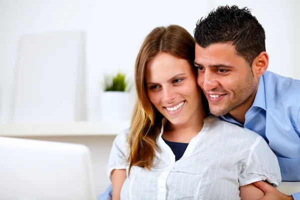 Romántica pareja joven en casa mirando a la computadora portátil —  Fotos de Stock