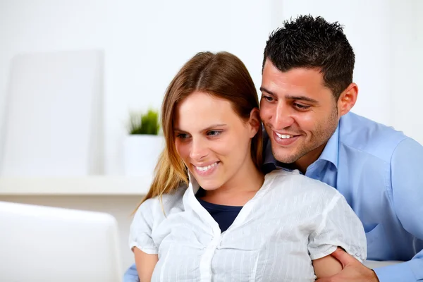 Adorável casal jovem navegando na Internet no laptop — Fotografia de Stock