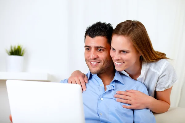 Χαμογελώντας νεαρό ζευγάρι χρησιμοποιώντας φορητό υπολογιστή — Φωτογραφία Αρχείου