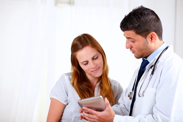 Attractive hispanic doctor conversing with a woman — Stock Photo, Image