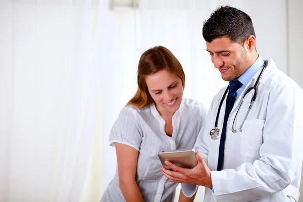 Stilig läkare och en kvinna som ser för att tablet pc — Stockfoto