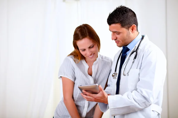 Knappe dokter en een vrouw op zoek naar tablet pc — Stockfoto