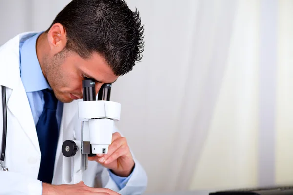 Atractivo médico hispano usando un microscopio — Foto de Stock