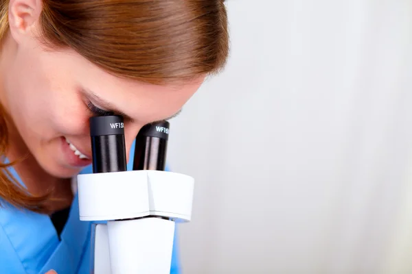 Mulher médica profissional usando um microscópio — Fotografia de Stock