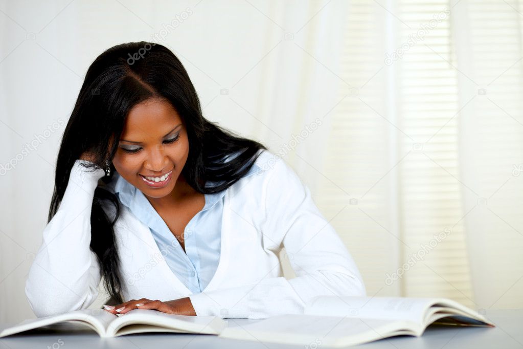 Beautiful black woman smiling and reading a book