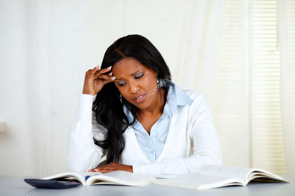 Stressed young black woman reading a book