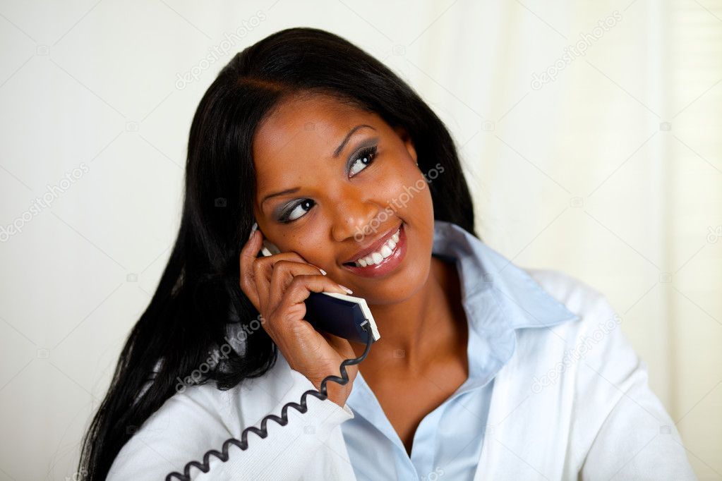 Young black woman conversing on phone