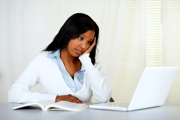 Отражающая молодая женщина учится на ноутбуке — стоковое фото