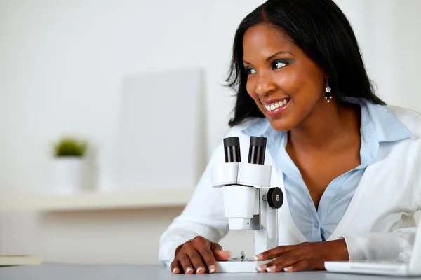 Bella donna nera che lavora con un microscopio — Foto Stock