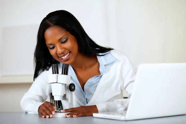 Американская чёрная женщина, работающая под микроскопом — стоковое фото