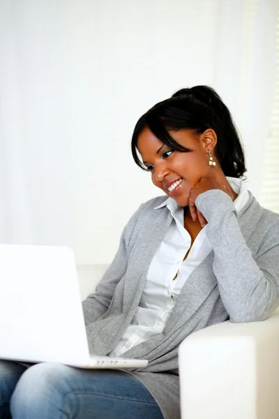 Krásná mladá žena s úsměvem a při pohledu na laptop — Stock fotografie