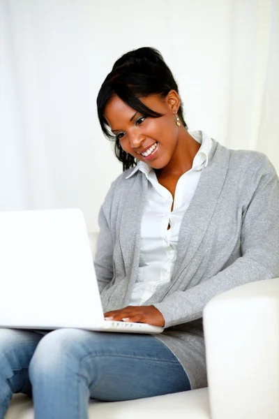 Ganska ung kvinna ler och ser till laptop — Stockfoto
