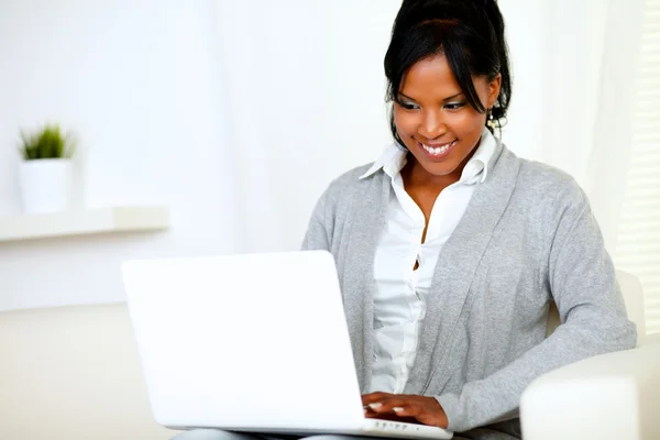 Усміхнена молода жінка використовує ноутбук — стокове фото