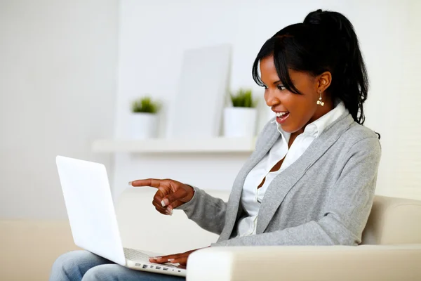 Mujer sorprendida señalando a la pantalla del ordenador portátil — Foto de Stock