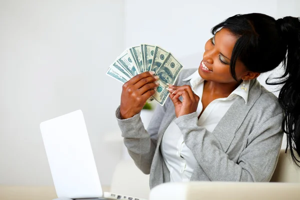 Счастливая женщина ищет доллары — стоковое фото