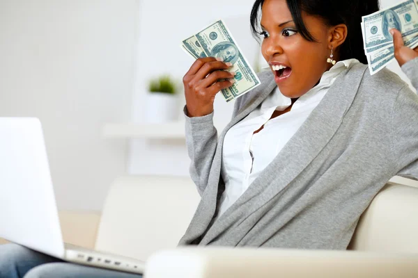 Mulher surpresa segurando muito dinheiro em dinheiro — Fotografia de Stock