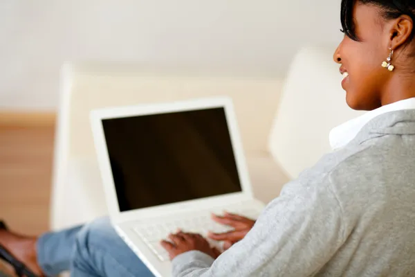 Siedzi piękna kobieta korzysta z laptopa podczas — Zdjęcie stockowe
