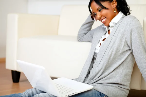 Lachende jonge vrouw die op laptop werkt — Stockfoto
