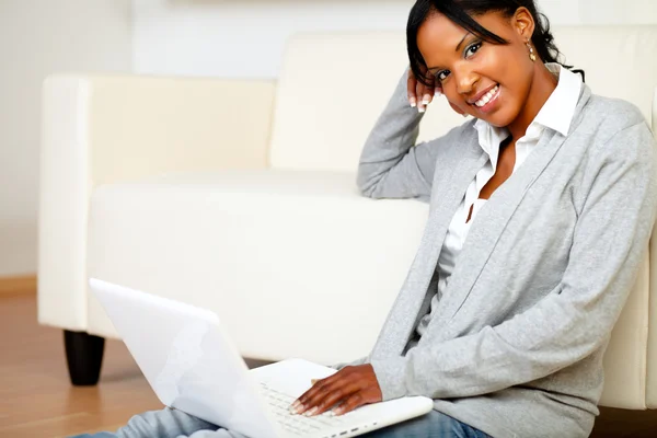 Расслабленная женщина улыбается тебе с ноутбуком — стоковое фото