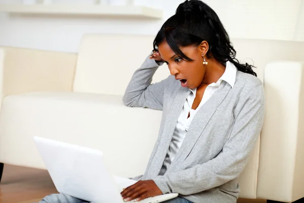 Verrast jonge vrouw lezen van een bericht op laptop — Stockfoto