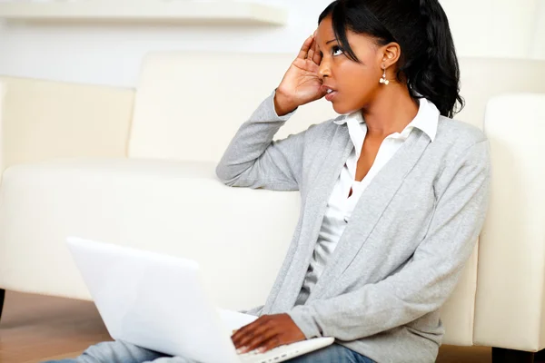 Наголошена молода чорна жінка працює на ноутбуці — стокове фото