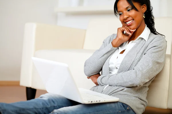 Linda jovem mulher sorrindo e olhando para laptop — Fotografia de Stock