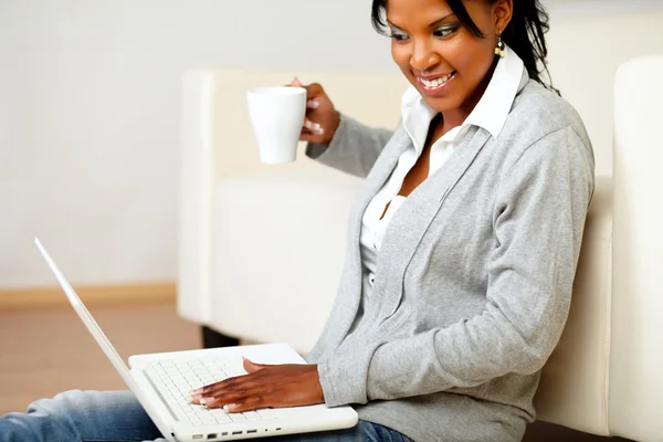 Jeune femme avec une tasse naviguant sur Internet — Photo