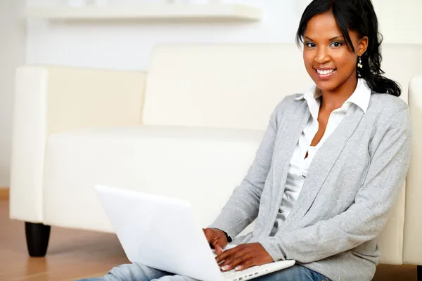 Relaxed young woman smiling at you with a laptop Stock Image
