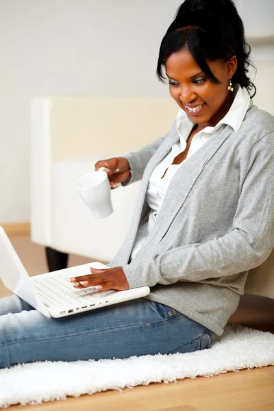 Όμορφη γυναίκα με μια κούπα μπροστά από το laptop — Φωτογραφία Αρχείου