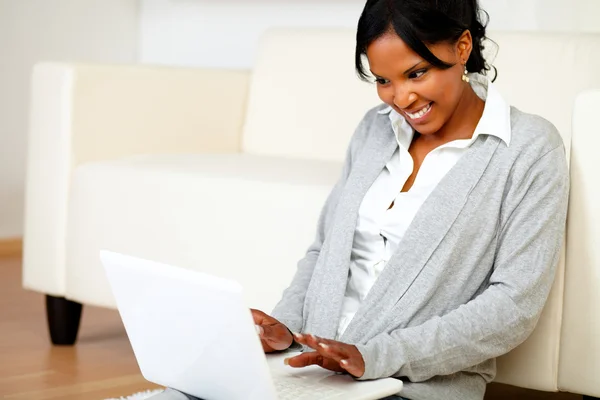 Щаслива молода жінка працює на ноутбуці — стокове фото