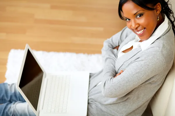 Vacker kvinna ler på dig med sin laptop — Stockfoto