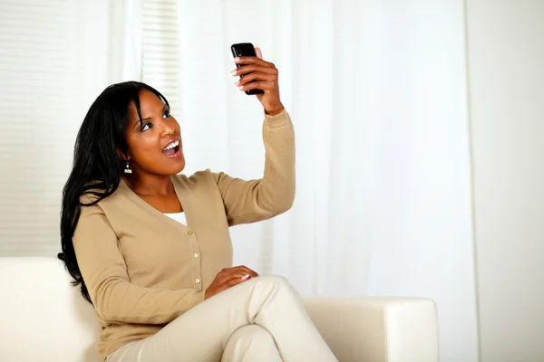 Удивлённая женщина держит свой телефон — стоковое фото