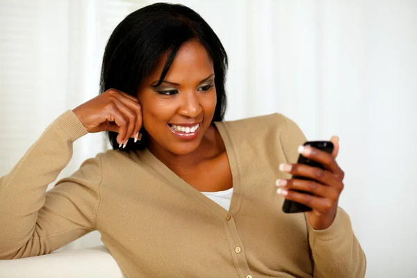 Mulher encantadora lendo uma mensagem em seu celular — Fotografia de Stock