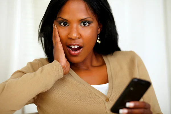 Überraschte Frau schaut zu dir und benutzt Handy — Stockfoto