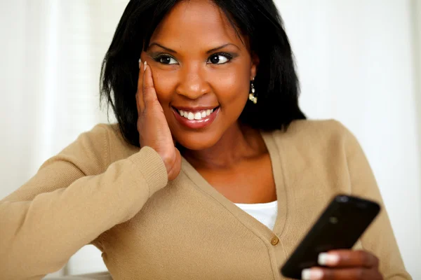Fundersam svart kvinna med hjälp av sin mobiltelefon — Stockfoto
