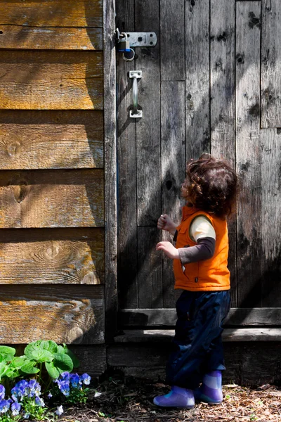 Little girl looking at a locked door — Stock Photo, Image