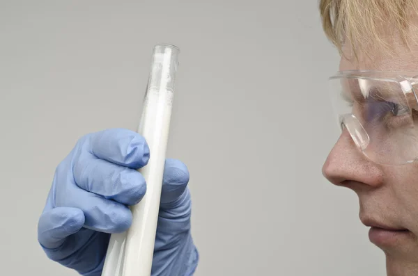 Científico mirando los tubos de ensayo en su mano —  Fotos de Stock