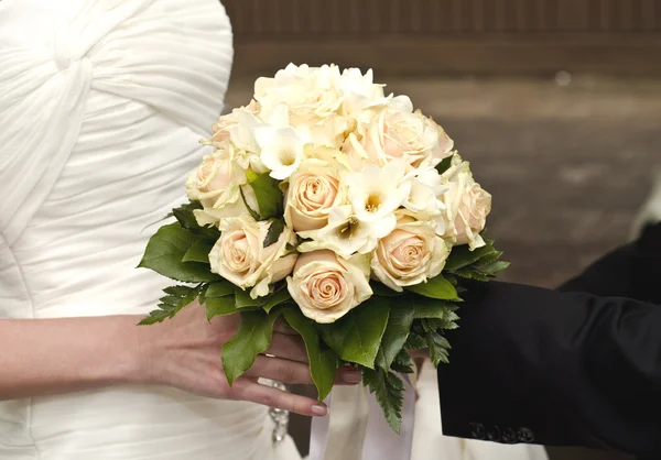 Wedding bouquet in hands of the bride and groom — Stock Photo, Image