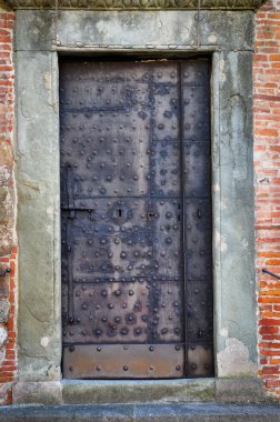 Rusty old metal door in the brick wall clipart