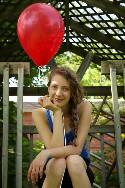 Подросток держит красный воздушный шар — стоковое фото